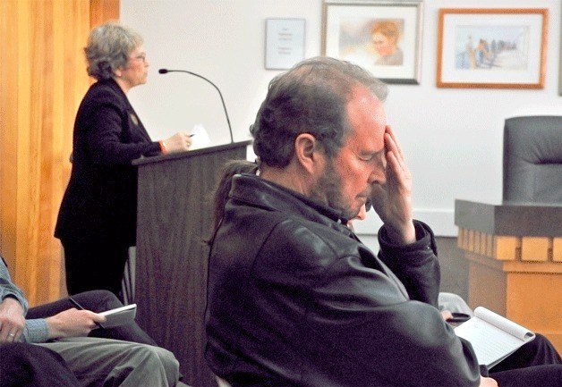 Sue Karahalios speaks at a recent hearing examiner hearing while longtime Oak Harbor developer Bill Massey listens. They have been engaged in a property dispute for nearly 10 years.