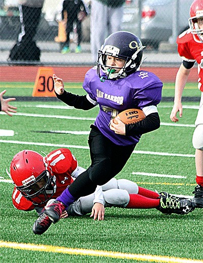 William Ward strikes a Heisman's pose while on the run for the Oak Harbor peewee team. Ward scored the first touchdown for Oak Harbor in the game against Stanwood.