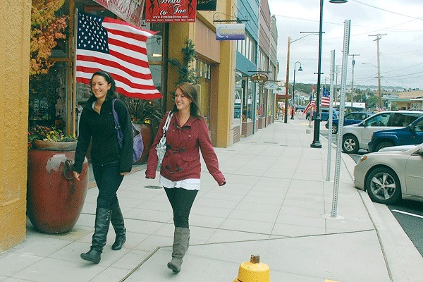 Oak Harbor residents Amber Hamming and Katie Krieg take a stroll down SE Pioneer Way on its brand new sidewalks. A ribbon cutting ceremony and a host of other activities will mark the street’s grand opening this weekend.