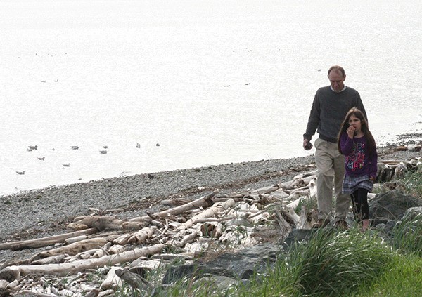 Randy Wall and his granddaughter Katrina Brady stroll down the beach at Monroe Landing Monday