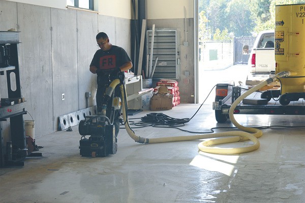 A worker with Tiger Construction hands the floor at the Island Transit maintenance building. Bubbles in the concrete had to be removed in order to complete the project.