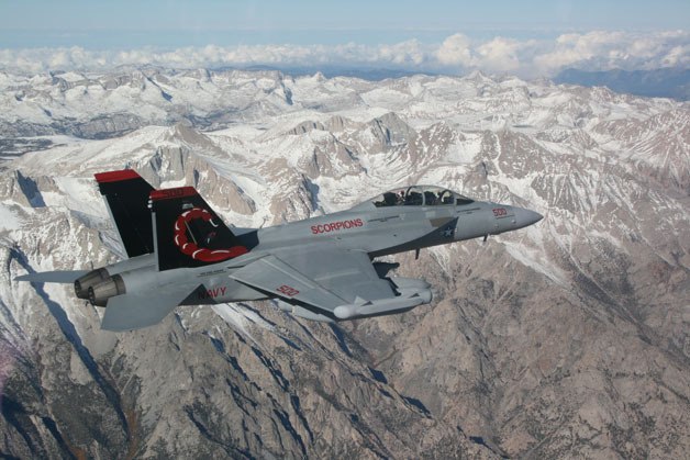 An EA-18G Growler soars over mountains. The Navy has been conducting electronic warfare training with the aircraft in the Olympic mountains for years.