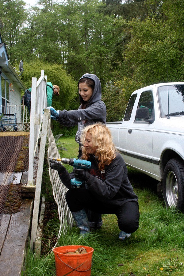 Sharlyn Hubbard and Jessica Schisel dismantle a ramp that was replaced thanks to the efforts of volunteers participating in the annual Hearts and Hammers work day.