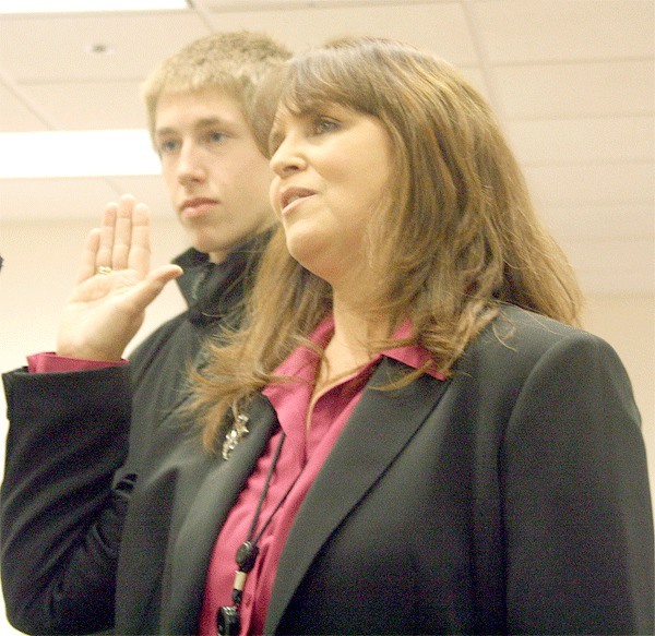 Island County Clerk Debra Van Pelt raises her hand Thursday afternoon as she is sworn in after winning her position in the November election. Her son