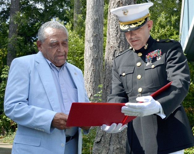 Marine Lt. Col. Jeff Symons presents Montford Point Marine Allen Frazier with the Congressional Gold Medal and the accompanying proclamation at a ceremony at Frazier’s Oak Harbor home Thursday.