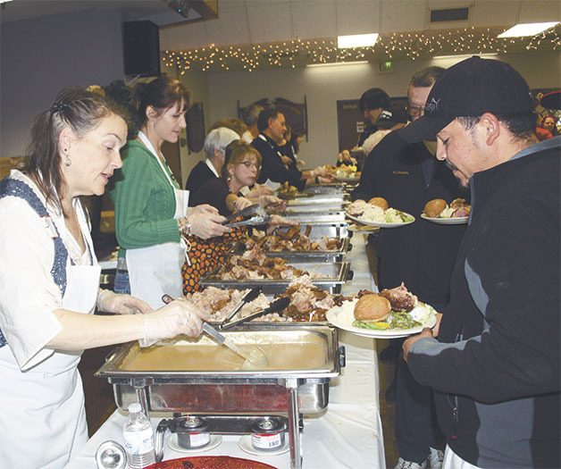 Volunteers help serve food at last year’s annual community Thanksgiving feast in Oak Harbor.