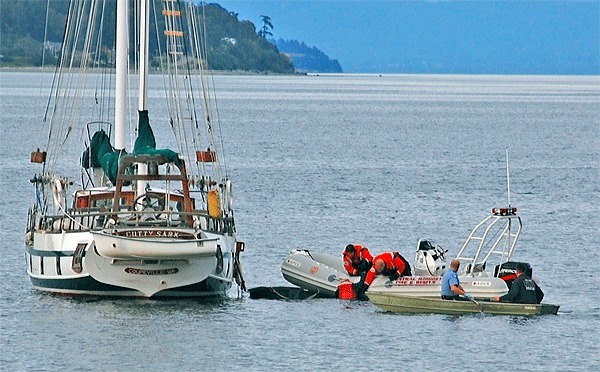 Central Whidbey Fire and Rescue emergency responders pull John Stone from the water in Penn Cove Thursday