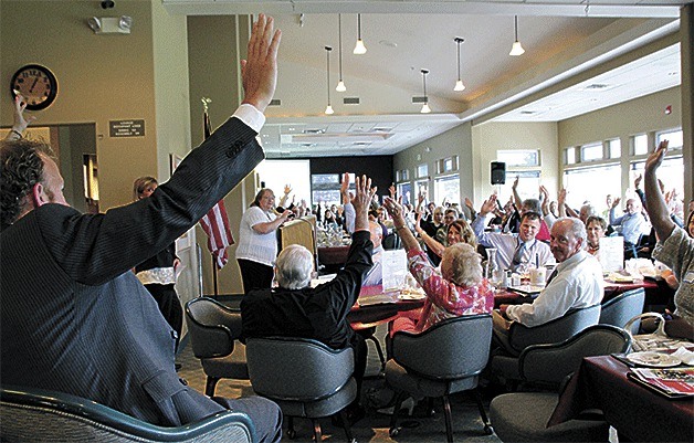 Members of the Oak Harbor Chamber of Commerce show their support for a resolution in support of the Navy base.