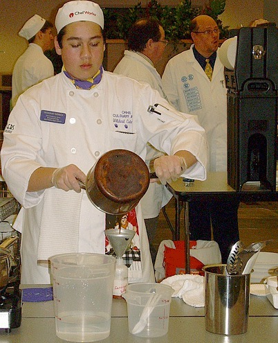 Culinary team member Nicholas Merrick pours the carmel sauce for the dessert.