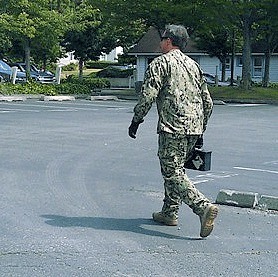 A member of the Navy Explosive Ordnance Detachment carries a box containing a suspected pipe bomb found at a Whidbey beach. Oak Harbor city buildings had to be evacuated after the man who found it brought it to the police station.