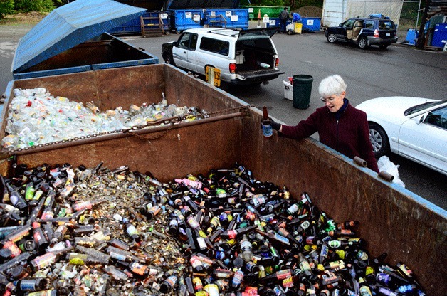 Coupeville resident Sally Fox tosses in the last of her recyclables at the recycle center just outside of town on Highway 20. Later that evening