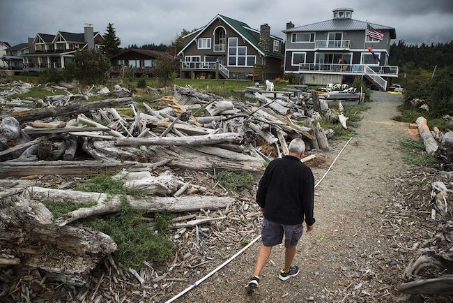 Cliff Marston walks to his house located on Camano Island’s Iverson Road on Sept. 7. Marston said water was about a foot deep on this path during a March storm that flooded some low-lying Island County homes.