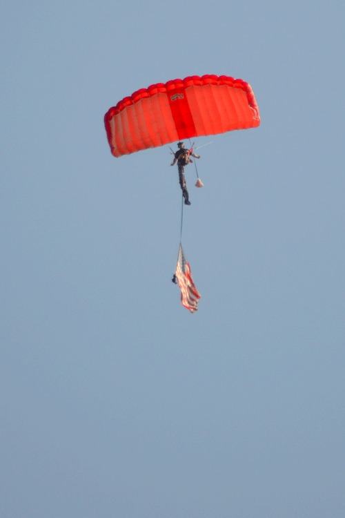 A parachutist glides in from the sky