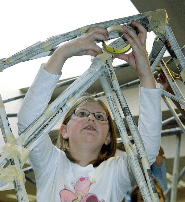 Fifth-grade student Bridget Barkley tapes newspaper tubes together to create a structure that taught students about area