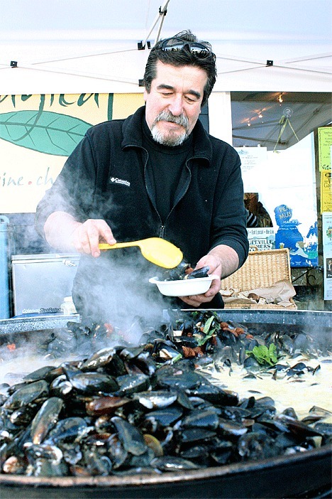David Day prepares mussels in front of Bayleaf Saturday during the Penn Cove MusselFest.