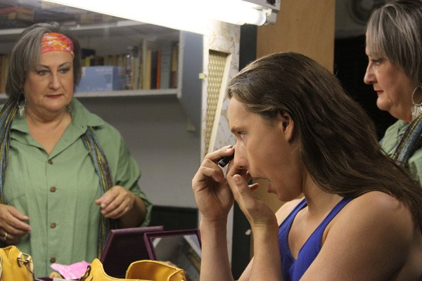 Penny Fowkes watches her son Wolly apply eye makeup before she takes her turn before a dress rehearsal for “Godspell” last week.