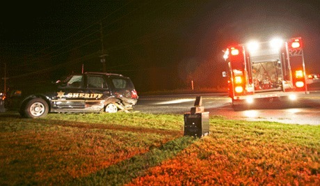 An Island County Sheriff's Deputy patrol SUV rests on the lawn of a Highway 20 home after being struck by a Dodge Stealth driven by Steven Larue