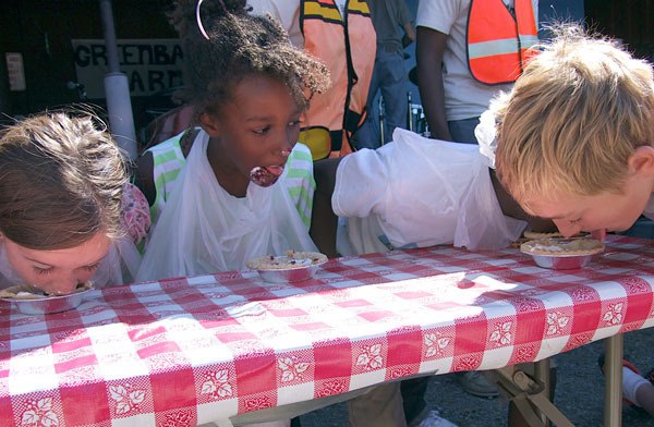 Pie-eating contestants race to finish their mini-pies during Saturday's Loganberry Festival at Greenbank Farm.