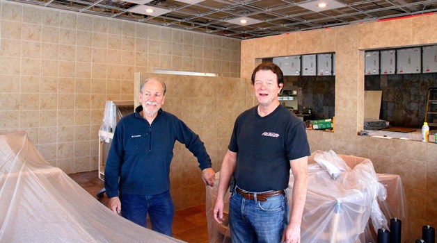 Ron Baxter (left) and Donald Dreyer pose amidst the remodeling of their Dairy Queen in Oak Harbor.