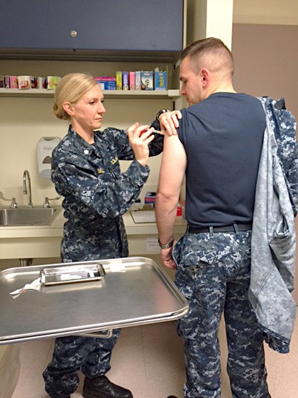 CDR Heather Sellers administers flu shot to HM2 Michael Waltich at Naval Hospital Oak Harbor.