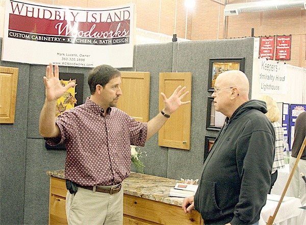 Whidbey Island Woodworks owner Mark Lucero talks to Coupeville resident Mark Skullerud during the Island County Biz Expo Saturday at the Coupeville Middle and High School gymnasium.