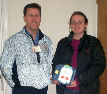 EMT Robert May and Melissa Jacobs show the defibrillator donated to the Hope Therapeutic Riding Center