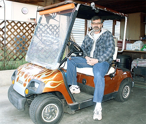 Coupeville resident Mike Czarnick sits at the wheel of his 1995 Yamaha golf cart