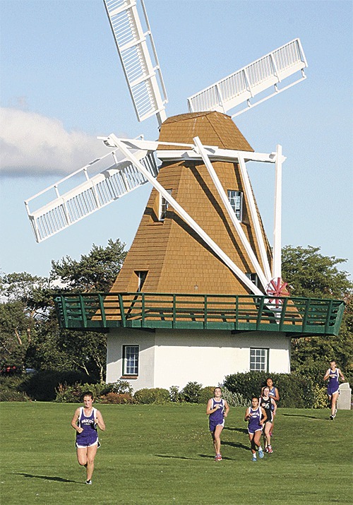 Cross country runners file by the iconic windmill at Windjammer Park in Oak Harbor's only home meet of the season.