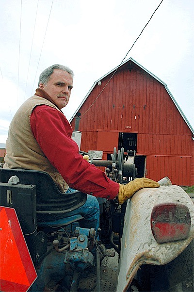 Central Whidbey farmer Don Sherman sits on his tractor in front of the barn his grandfather built nearly 80 years ago. The aging structure recently got an overhaul thanks to the Ebey’s Forever Fund.