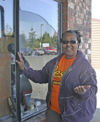 Pastor Fannie Dean inspects a broken window on her Oak Harbor Thrift Store