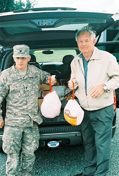 PFC Mark Fakkema starts unloading the turkeys and other items he purchased with his own money to assure a merry Christmas for 14 North Whidbey families. Helping is his grandfather