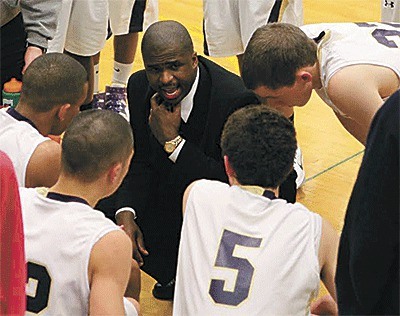 Oak Harbor High School basketball coach Mike Washington talks to his team during a break in the action. Washington resigned Wednesday as the Wildcats' coach.