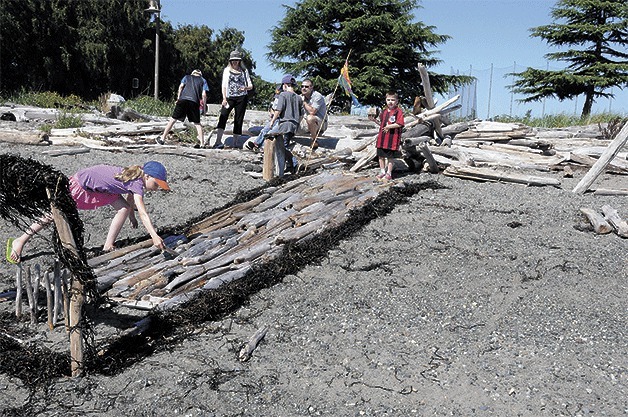 A young participant creates a piece of art out of driftwood during Driftwood Day along Oak Harbor’s waterfront Saturday.