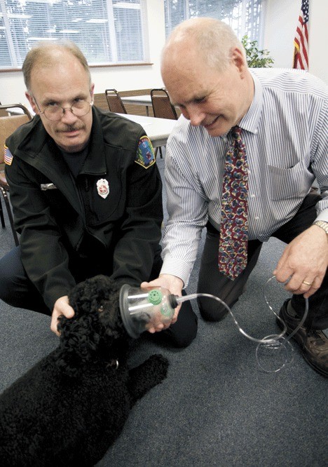 Veterinarian Dr. Eric Anderson and North Whidbey Fire and Rescue firefighter George Lawson demonstrate the use of an animal oxygen mask on Charlie