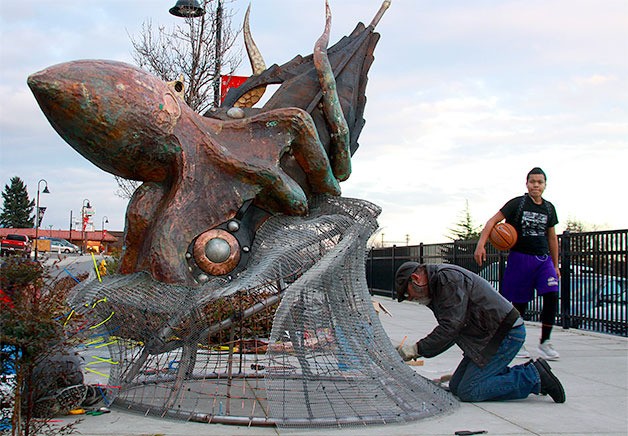 A passerby gets a look Wednesday at the new kraken sculpture created by Oregon artist Bill Hunt