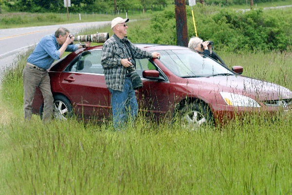 Clinton resident Paul Lischeid and Freeland residents Bruce and Reveilly Barchenger photograph eagles Wednesday from the side of Highway 20 south of Oak Harbor.