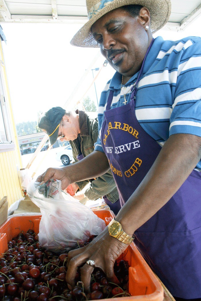 Oak Harbor Lions Club member James House scoops cherries that are being sold to support the club’s charitable efforts.