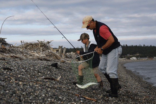 Bob Eckles lifts a pink salmon caught by his son