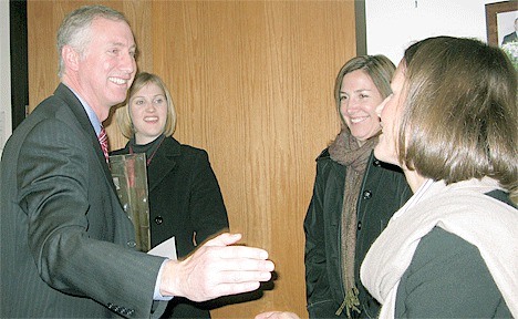 Mike Merringer is surprised after his award is announced at a meeting in December. From the left are his daughter