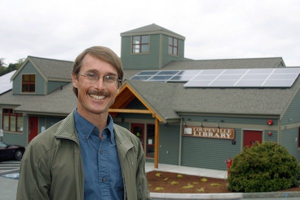 Kelly Keilwitz of Whidbey Sun and Wind stands in front of a solar energy project recently installed at the Coupeville Public Library. The Greenbank Farm could be the next solar project should officials receive funding.