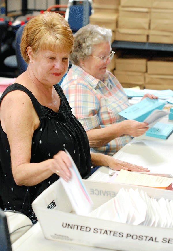 Heather Porter of Langley and Dodie Handy of Greenbank assemble envelopes in preparation for mailing later this week.
