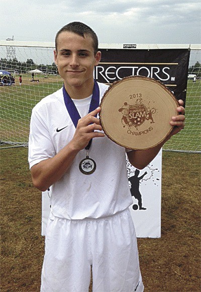 Chase Muller holds the first-place award won by his soccer team at the Summer Slam last weekend.