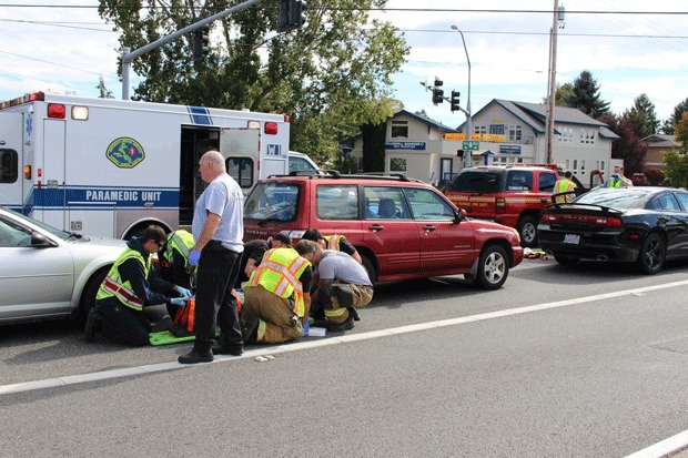 Firefighters help a woman injured a five-car crash in Oak Harbor.