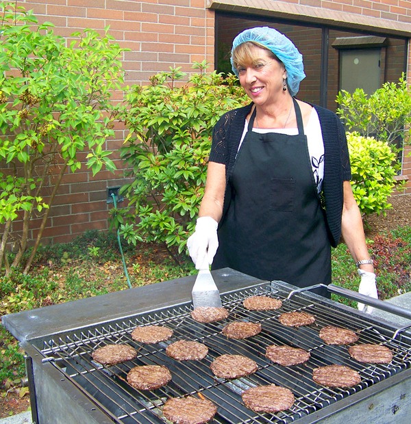 CEO Geri Forbes stands behind the grill and serves employees during The Whidbey General Hospital and Employee Council’s annual summer picnic
