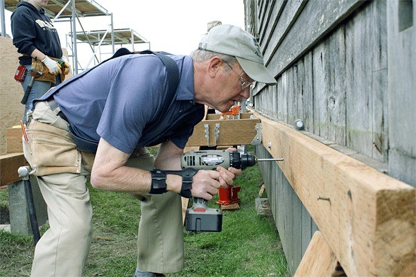 Volunteer John Roomes helps install a porch at the Ferry House