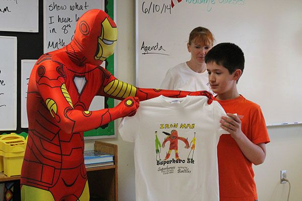 Iron Man surprises Brennan Sanchez with a T-shirt featuring his drawing in honor of the Superhero 5K.