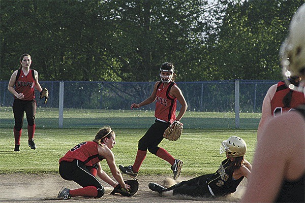Coupeville shortstop Maria Rockwell tags out a would-be Meridian base stealer as second baseman Chevy Reyes and centerfielder Haley Sherman back up the play.
