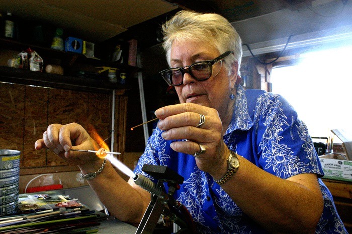 Bev McQuary turns up the heat to blow glass beads. She is one ov many artists participating in the Whidbey Open Studio Tour Oct. 8 and 9.