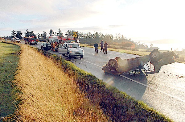 An overturned Volvo sits on its roof near Arnold Road on Highway 20 Tuesday morning. The wreck resulted in two women receiving injuries