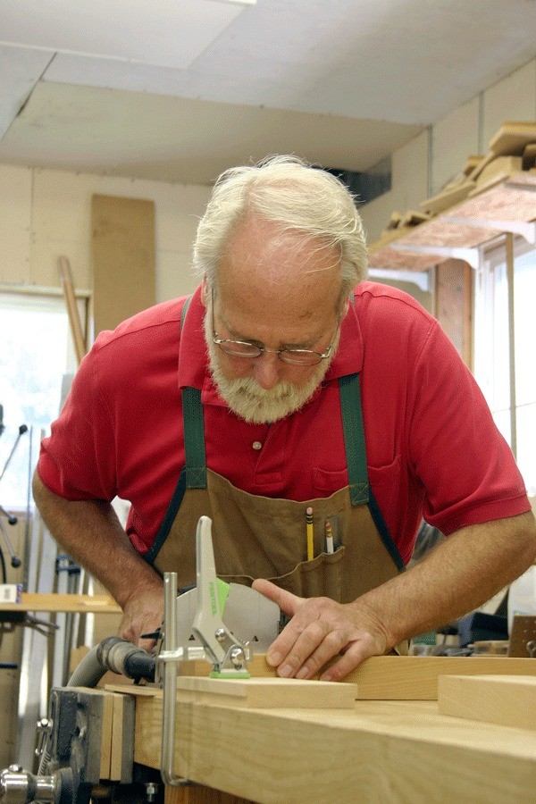 Woodworker Robert Bennett prepares pieces for a cabinet.